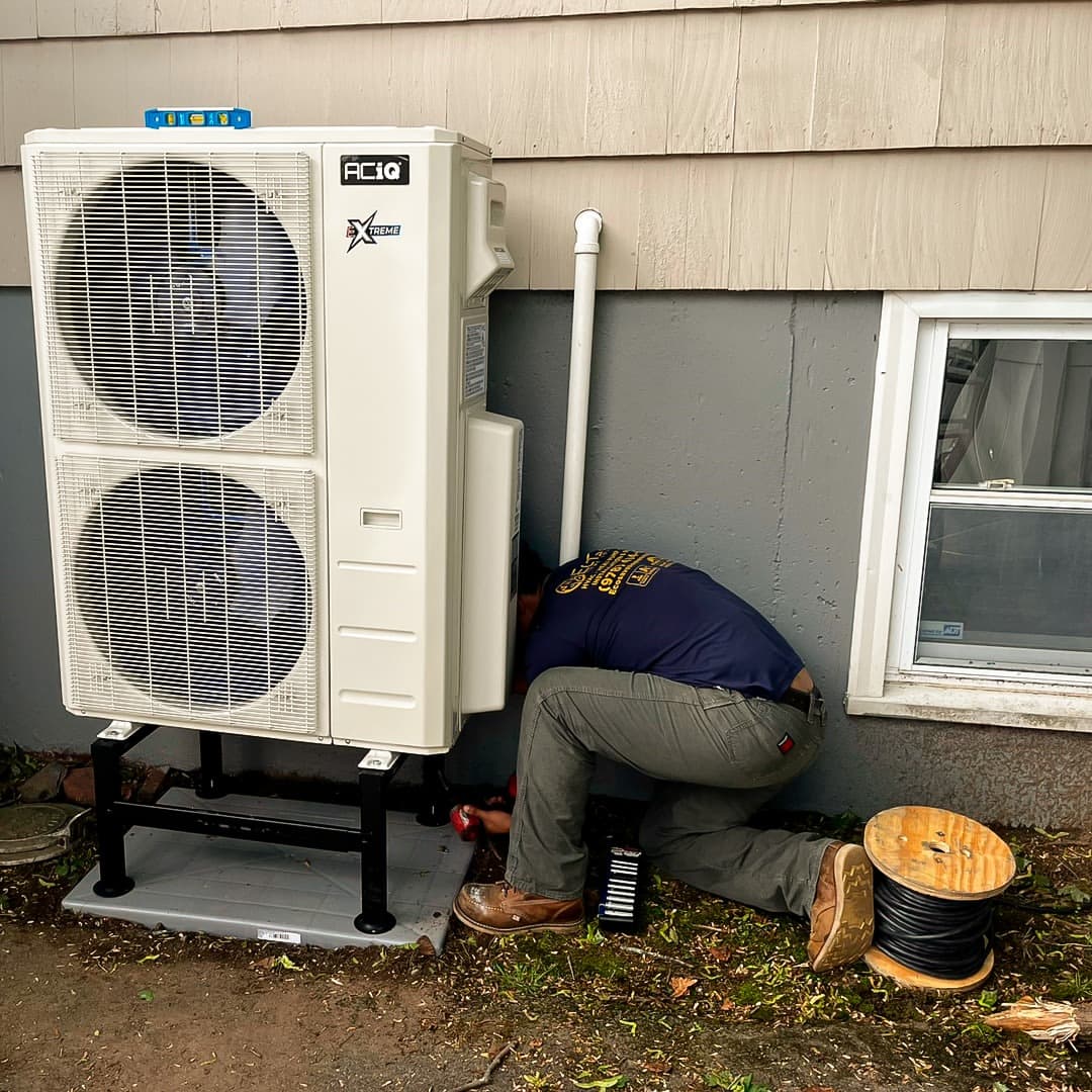 An EcoSave technician checking the connections on a newly installed heat pump