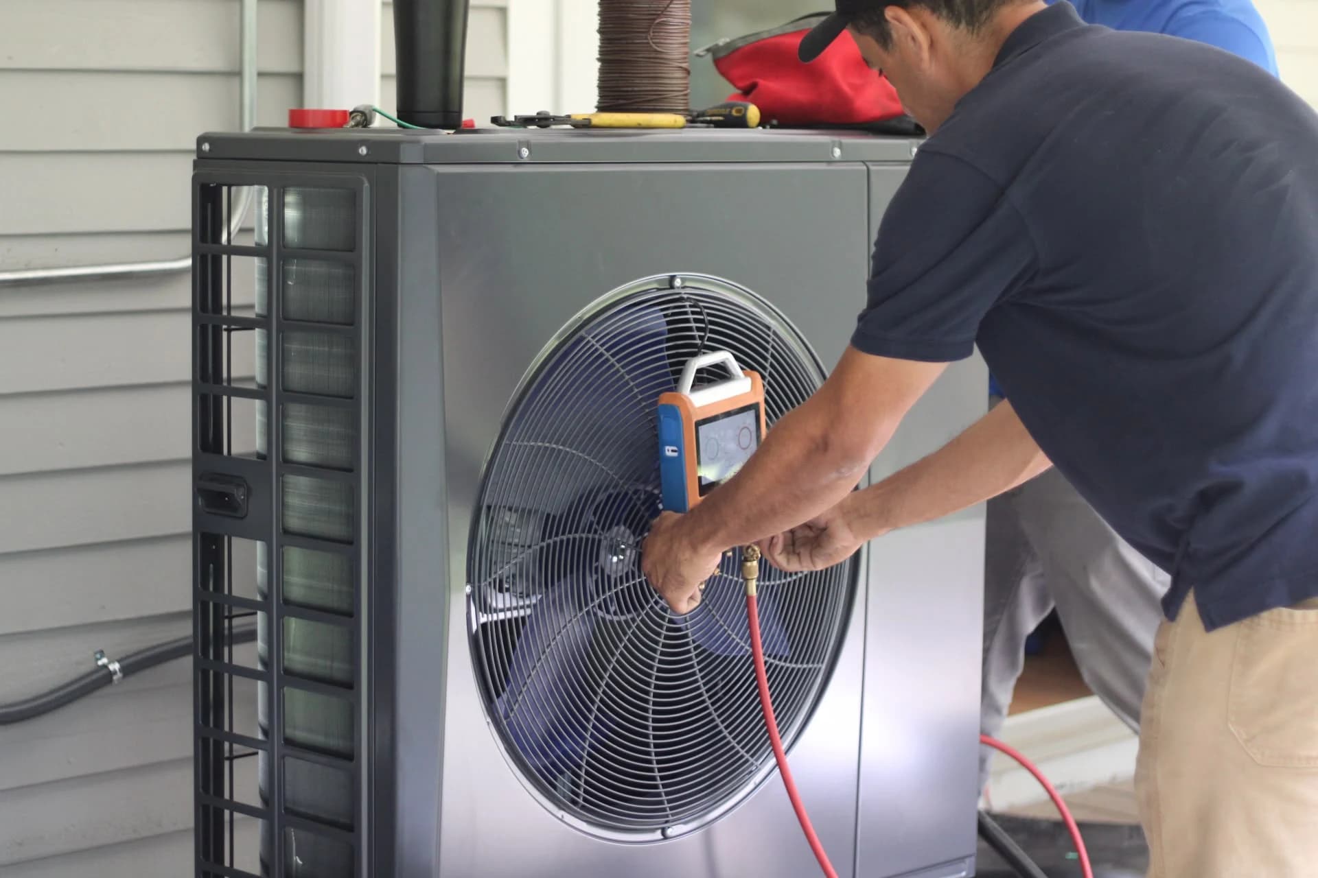 EcoSave technician working on an outdoor heat pump during installation