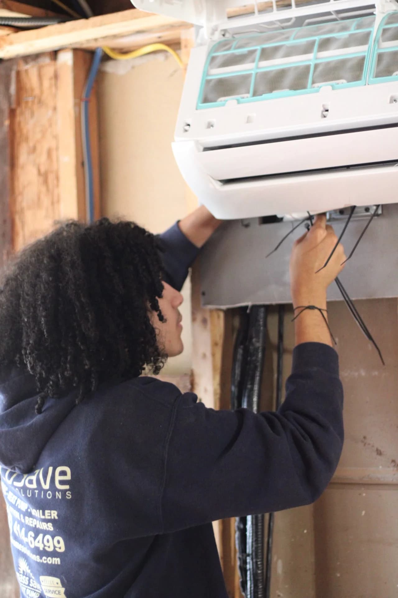 EcoSave technician working on an indoor mini-split in a room under renovation